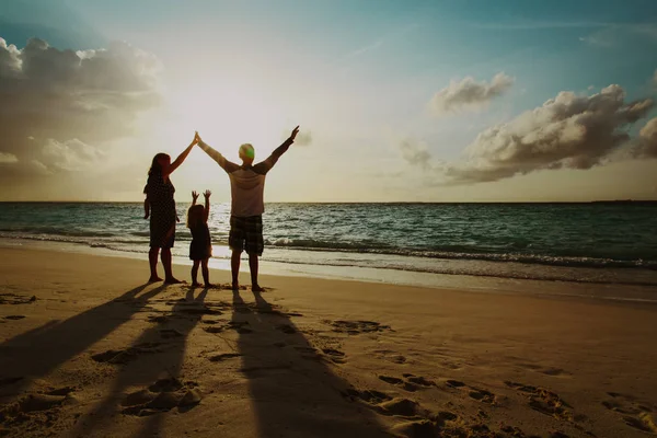 Família feliz com crianças brincam na praia do pôr do sol — Fotografia de Stock