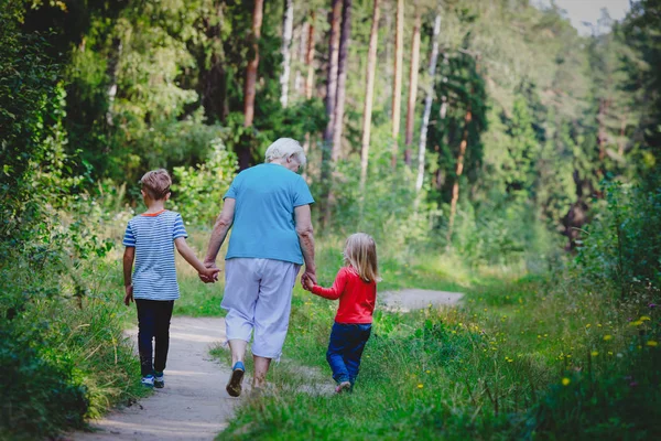 Oma met kinderen lopen in de natuur, grootouders — Stockfoto