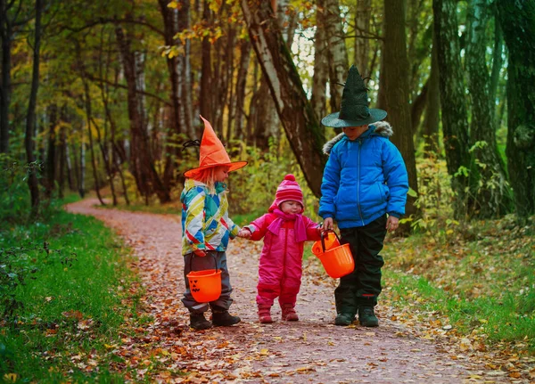 Niños en halloween disfraz truco o tratar en otoño naturaleza — Foto de Stock