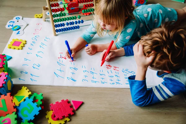 Liten pojke och flicka lära sig skriva och beräkna tal — Stockfoto