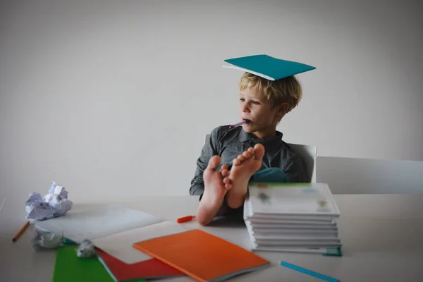 Ung pojke låtsas göra läxor avslappnad hemma — Stockfoto