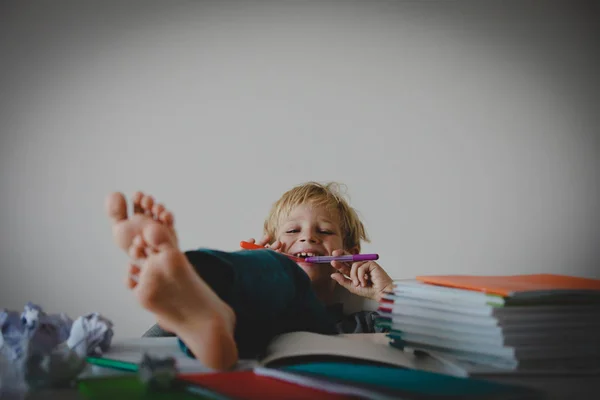 Ung pojke låtsas göra läxor avslappnad hemma — Stockfoto