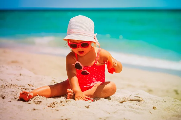 Cute little girl grać z piasku na plaży — Zdjęcie stockowe