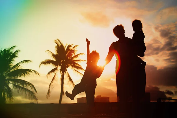 Σιλουέτα της οικογένειας με παιδιά που παίζουν στο sunset beach — Φωτογραφία Αρχείου