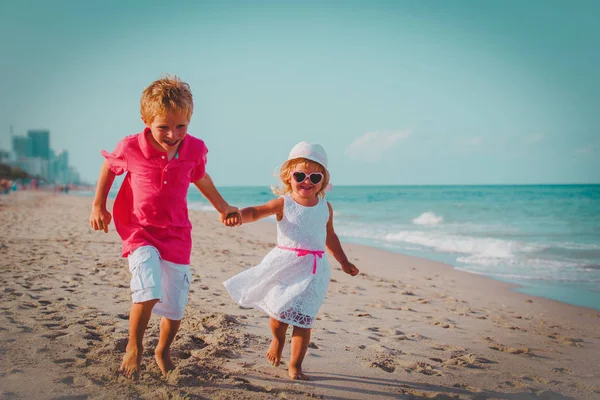 Kleine jongen en meisje draait op strand — Stockfoto