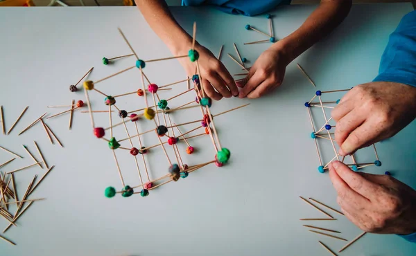 öğretmen ve geometrik şekiller yapmak çocuk sopa ve oyun hamuru