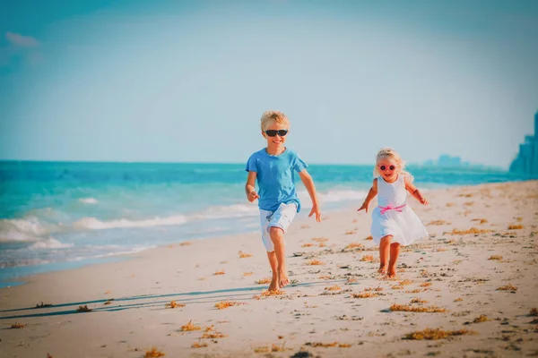 Kleine jongen en meisje lopen spelen op strand — Stockfoto