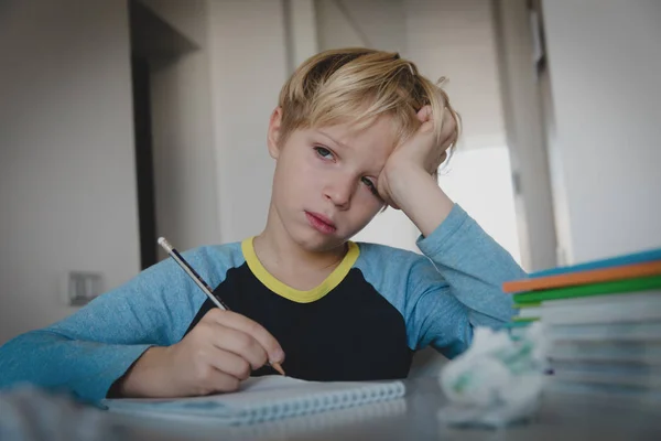 Lille pojken trött stressad av göra läxor, uttråkad, utmattad — Stockfoto