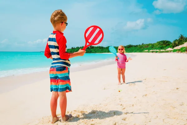 Küçük erkek ve kız plaj tatil plaj tenisi oynamak — Stok fotoğraf