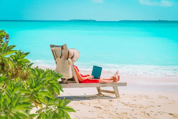 Концепція віддаленої роботи - молода жінка з ноутбуком на пляжі — стокове фото