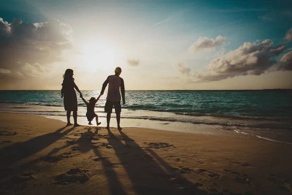 Ευτυχισμένη οικογένεια με δύο παιδιά στο play στην παραλία ηλιοβασίλεμα — Φωτογραφία Αρχείου