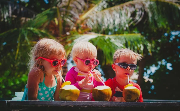 Niños felices bebiendo cóctel de coco en el resort de playa — Foto de Stock