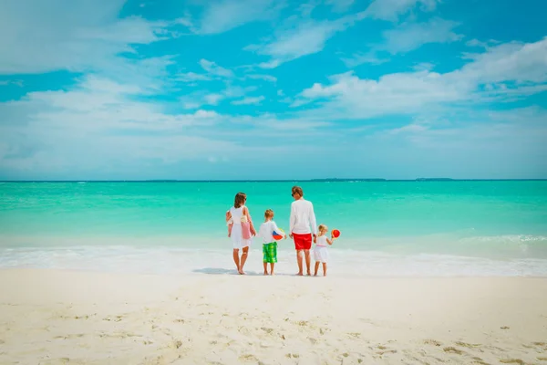 Üç çocuklu mutlu bir aile sahilde yürüyor. — Stok fotoğraf