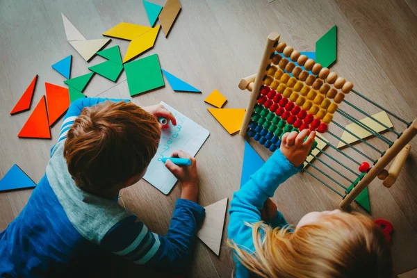 Мальчик и девочка учатся писать и подсчитывать числа — стоковое фото