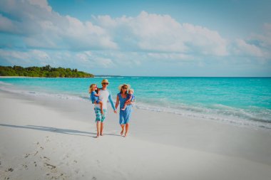 İki çocuklu aile tropik sahilde yürümek