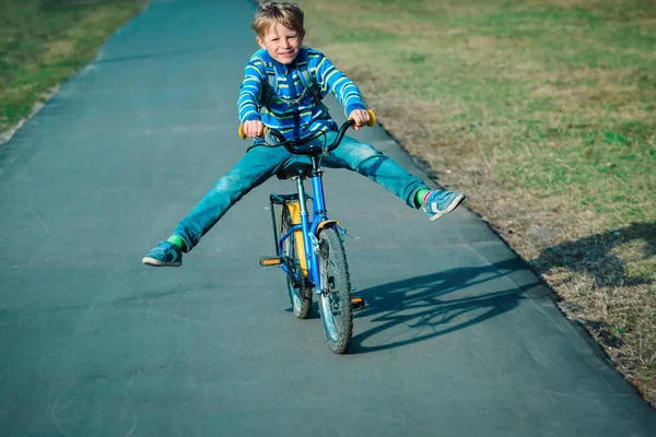 Маленький мальчик делает трюки катание на велосипеде на открытом воздухе — стоковое фото