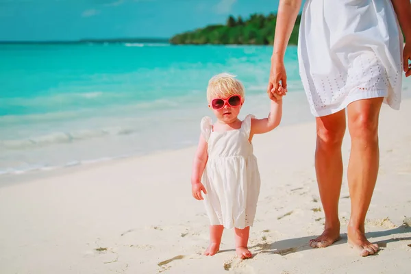 Mother and cute little daughter walking on beach — Stock Photo, Image