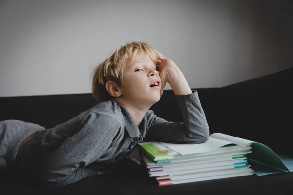 Kisfiú fáradt az olvasás, hangsúlyozta csinál házi feladatot — Stock Fotó