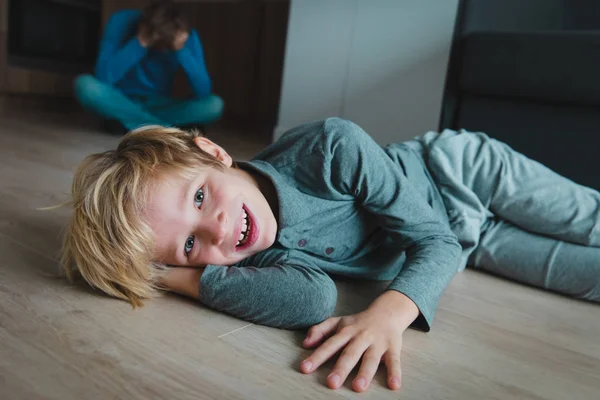 Svårt föräldraskap-far är trött medan sonen ler, gör ofog — Stockfoto