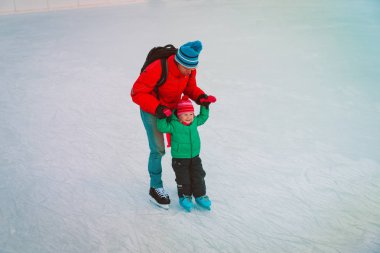 Baba ve küçük kızı kışın paten için öğrenme