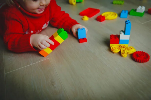 Pequeno bebê brincando com blocos de plástico coloridos — Fotografia de Stock