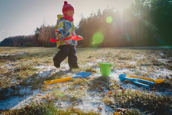 Маленькая девочка играет с первым снегом в природе — стоковое фото