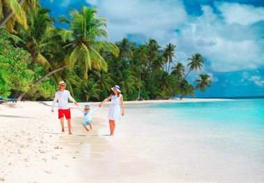 Kumsalda oynayan çocuk ile mutlu aile