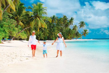 Kumsalda oynayan çocuk ile mutlu aile