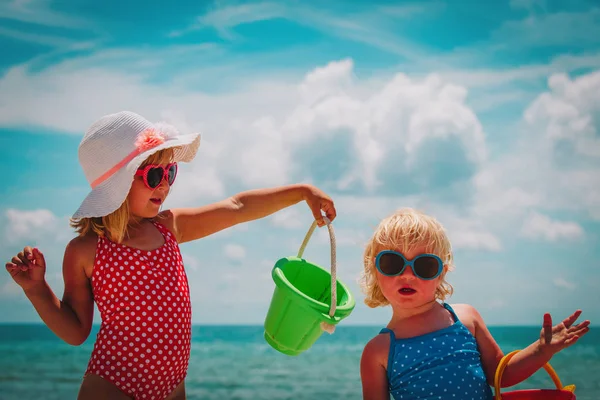 Μικρά κορίτσια παίζουν με άμμο στην παραλία το καλοκαίρι — Φωτογραφία Αρχείου