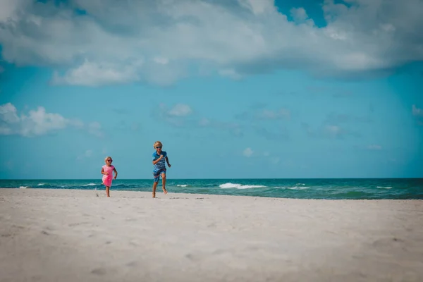 Felice bambino e ragazza correre giocare in spiaggia — Foto Stock