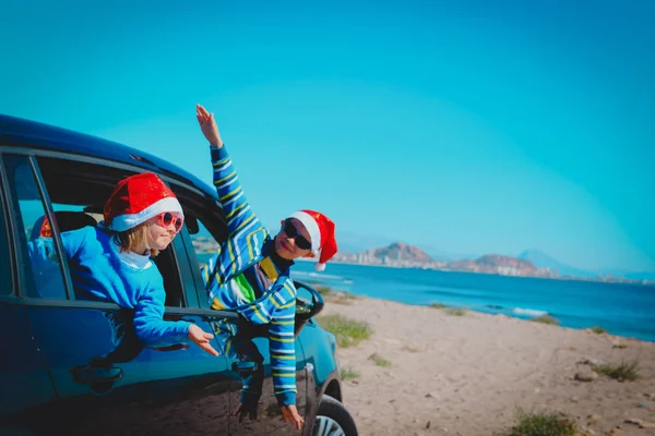 christmas car travel- happy kids travel in winter on beach