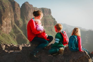 Aile çocuklarla seyahat manzaraya bakarak dağlar'da yürüyüş