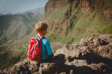 küçük çocuk manzaraya bakarak dağlarda hiking