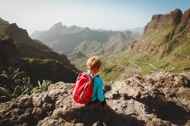 küçük çocuk manzaraya bakarak dağlarda hiking