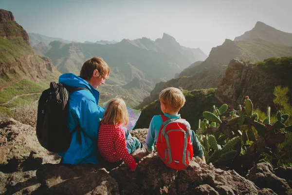 Familj med barn reser vandring i bergen tittar på karta — Stockfoto