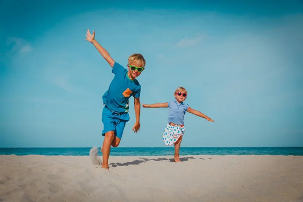 Feliz chico y chica ejecutar jugar en la playa —  Fotos de Stock