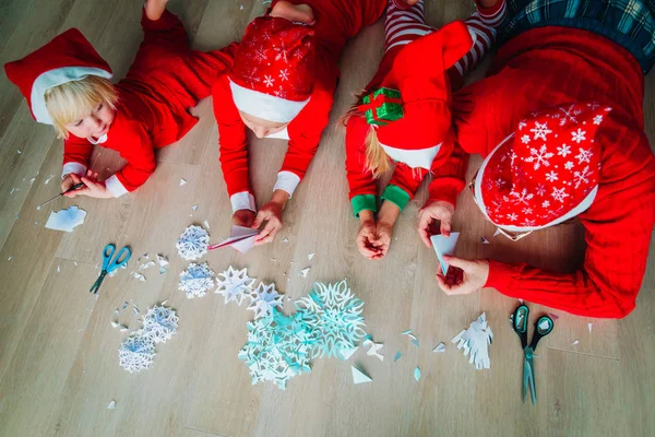 Родина робить сніжинки з паперу, різдвяні вироби — стокове фото