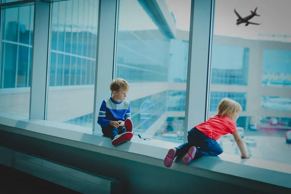 Niño y niña esperando avión en el aeropuerto —  Fotos de Stock