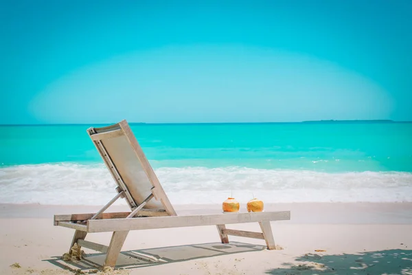 Два кокосовых напитка и стул на тропическом пляже — стоковое фото