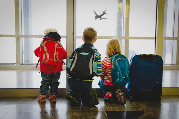 Niños esperando viajar mirando aviones en el aeropuerto — Foto de Stock