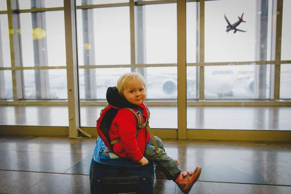 Милая маленькая девочка на чемодане путешествия в аэропорту — стоковое фото