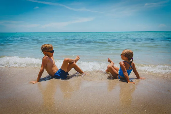 Kleine jongen en meisje ontspannen op tropisch strand — Stockfoto