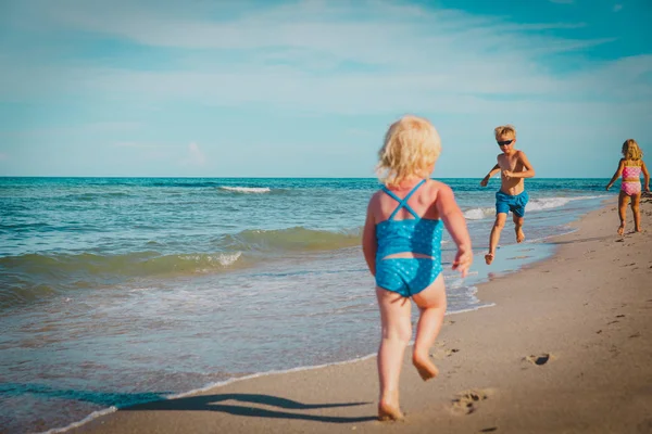 Mutlu çocuklar - küçük oğlan ve kız tarafından işletilen oyun Beach — Stok fotoğraf