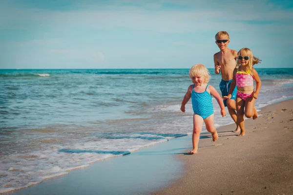 Happy kids -little boy and girls- run play at beach — Stock Photo, Image