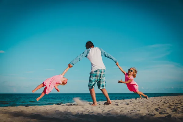 Отец с счастливыми детьми играют на пляже — стоковое фото
