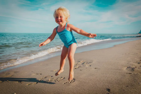 Щаслива дитина грає стрибок на піщаному пляжі — стокове фото