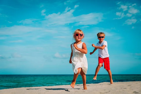 Kleine jongen en meisje met spelen op het strand — Stockfoto