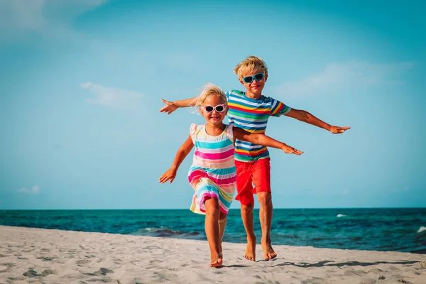 Feliz chico y chica ejecutar jugar en la playa — Foto de Stock