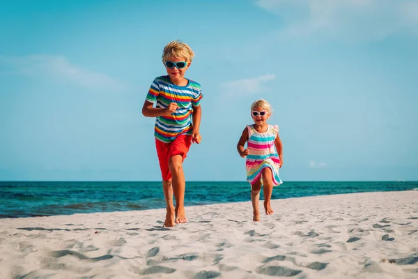 Niño y niña corriendo jugar en la playa — Foto de Stock