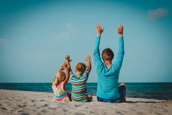 Padre con pequeño hijo e hija divirtiéndose en la playa — Foto de Stock